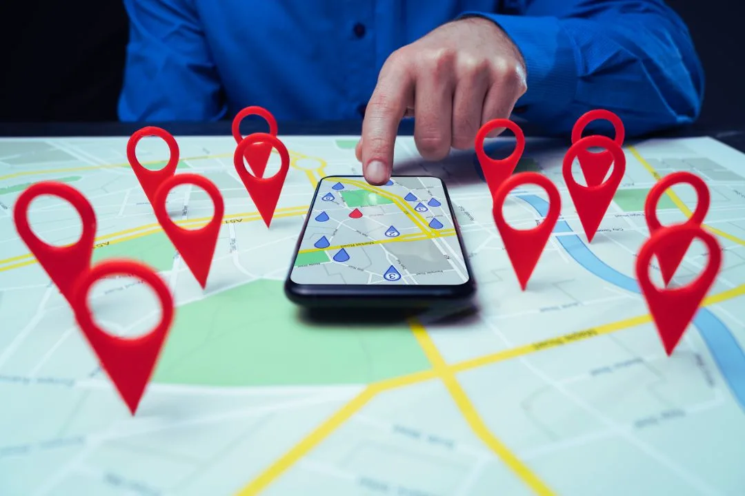 Google Local Search-min Hand wijst op smartphone met kaart en locatiepins – visualisatie van lokale zoekresultaten in Google.